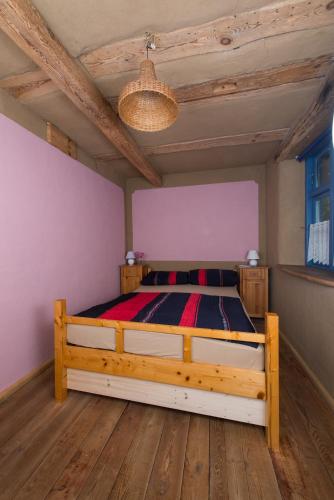a bedroom with a wooden bed in a room at Alte Schule Ludwigsburg in Loissin