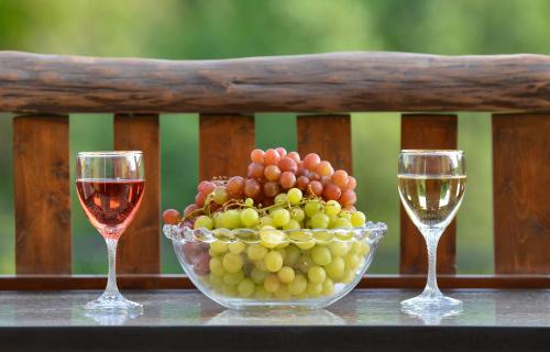 a bowl of grapes and two glasses of wine at Andri House in Marathias