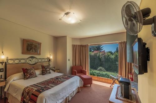Pokój hotelowy z łóżkiem i wentylatorem w obiekcie Antuquelen w mieście Villa La Angostura