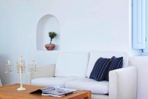 a living room with a white couch and a table at Aria Suites & Villas in Fira