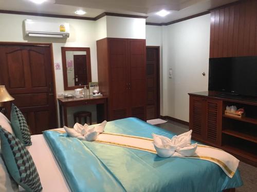 a room with a bed with flowers on it at Busyarin Hotel in Nong Khai