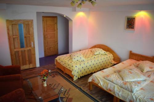 a bedroom with two beds and a glass table at Casa Parvu in Lunca Mare