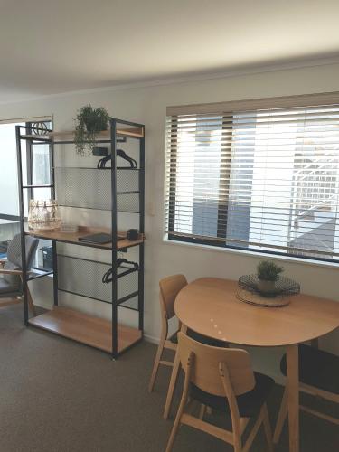 a room with a table and a table and chairs at Capri on Pilot Bay in Mount Maunganui