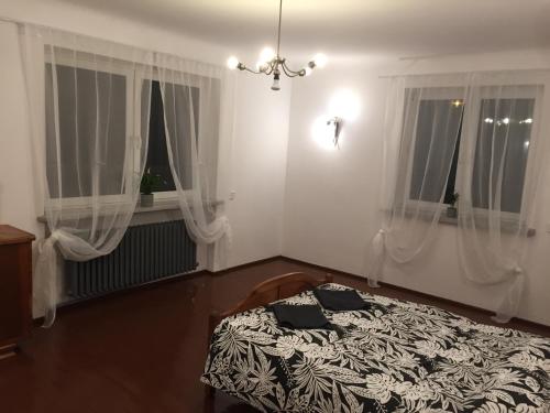 sypialnia z łóżkiem i dwoma oknami w obiekcie Dom Warszawa/Legionowo w mieście Legionowo