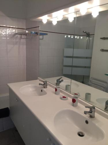 een badkamer met 2 wastafels en een grote spiegel bij T 3 appart les jardins du phœbus in Gruissan