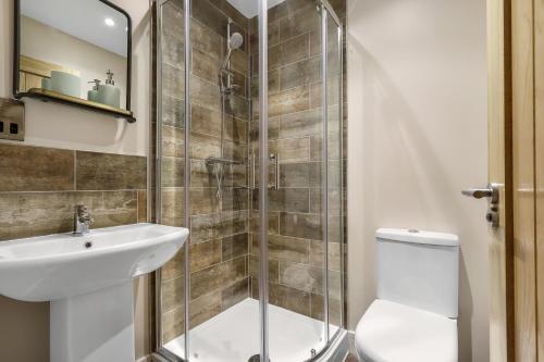 a bathroom with a shower and a toilet and a sink at Executive Apartments in Andover