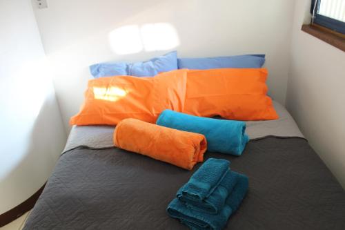 a bed with orange and blue pillows in a room at LA SERRA 211 in Ivrea