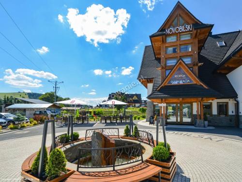 un bâtiment avec un panneau en face d'une rue dans l'établissement Novobilski - obok Termy Bania, à Białka Tatrzańska