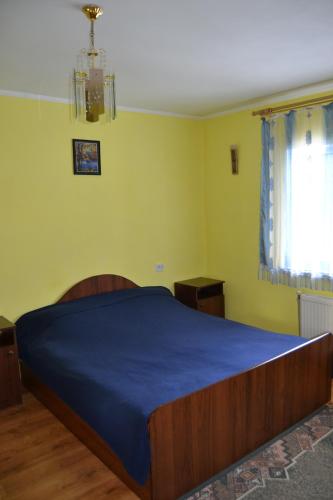 a bedroom with a large bed with a blue blanket at Карпатський Дуб in Yaremche