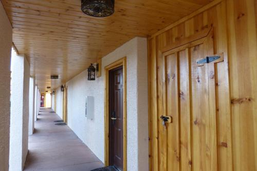 an empty hallway with a wooden door in a building at Grand Canyon Inn and Motel - South Rim Entrance in Valle