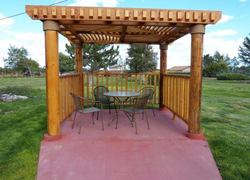 a wooden gazebo with a table and chairs at Grand Canyon Inn and Motel - South Rim Entrance in Valle
