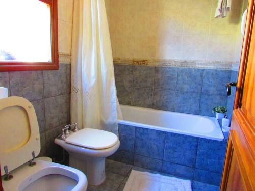 a bathroom with a toilet and a tub and a sink at Pilgrim's Rest - Descanso del Peregrino in Chacras de Coria