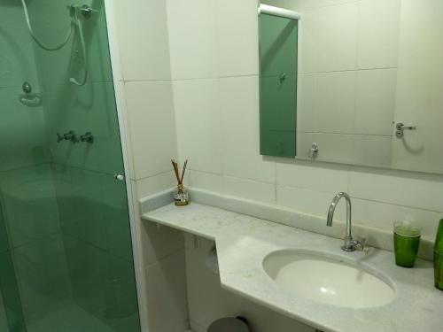 a bathroom with a sink and a shower with a mirror at Condado - Condomínio Aldeia dos Reis - Sahy - BL03 AP101 in Mangaratiba