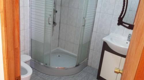 y baño con ducha, aseo y lavamanos. en Hotel Nogal, en Constitución