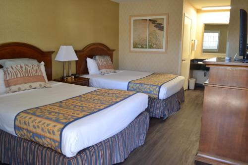 a hotel room with two beds and a television at Valley Inn San Jose in San Jose