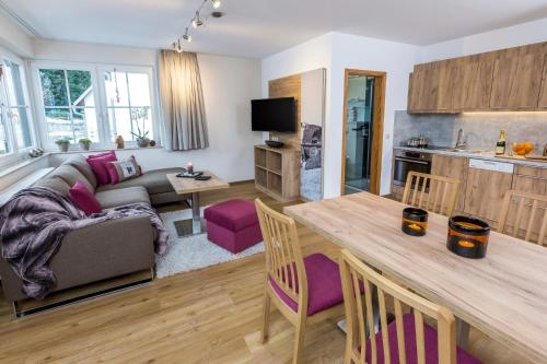 a kitchen and living room with a table and purple chairs at Simon´s Ferienwohnungen in Kurort Oberwiesenthal