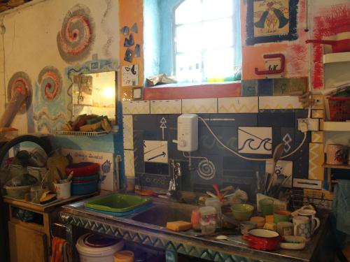 a cluttered kitchen with a sink and a window at Pod tulipanem nad jeziorem in Zawady Oleckie