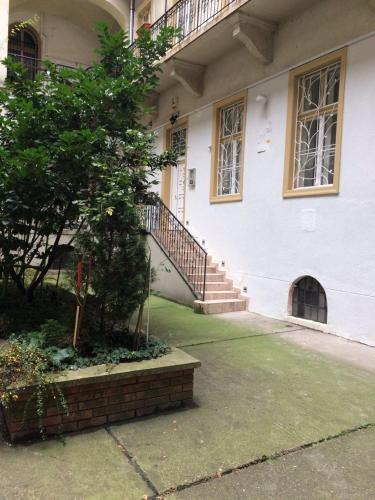 a building with a staircase and a tree in front of it at Platanus Guesthouse in Budapest