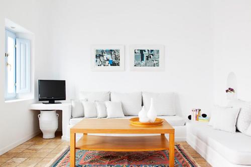 a living room with a white couch and a coffee table at Aria Suites & Villas in Fira