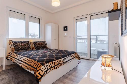 - une chambre avec un lit et de grandes fenêtres dans l'établissement Apartment Terrace, à Belgrade