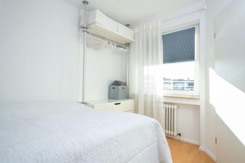 um quarto branco com uma cama e uma janela em Cute & Cozy em Wiesbaden