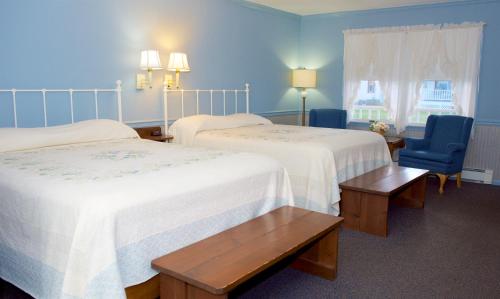 a hotel room with two beds and a chair at Myer Country Motel in Milford