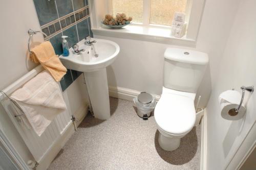 a bathroom with a white toilet and a sink at Midway Guest House in York