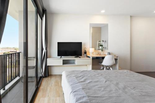 a bedroom with a bed and a flat screen tv at Nidhra นิทรา in Ban Lat Krachaeng