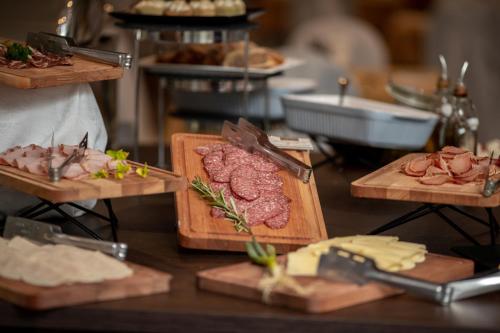 a table topped with different types of meats and cheese at New City Hotel & Restaurant Niš in Niš