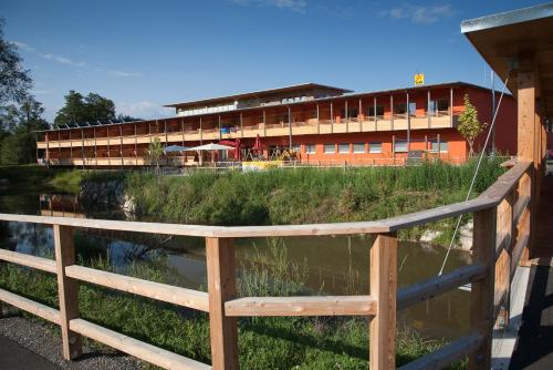 a building with a fence and a body of water at JUFA Hotel Leibnitz in Leibnitz