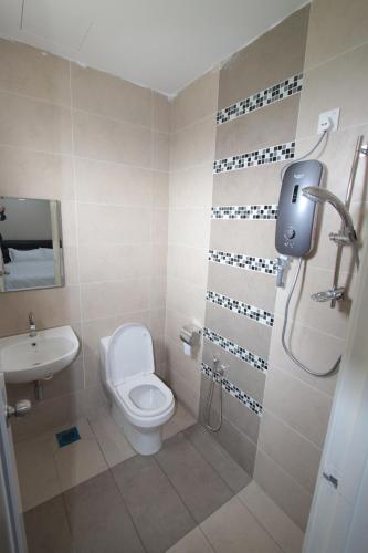 a bathroom with a toilet and a sink at KompoVilla House No 30 in Kuantan