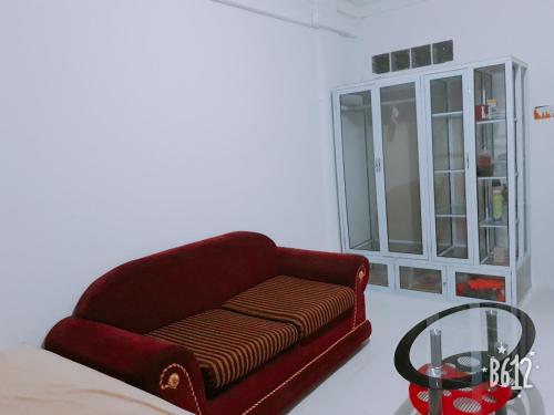 a red couch in a room with a window at Jakson Homestay in Batam Center