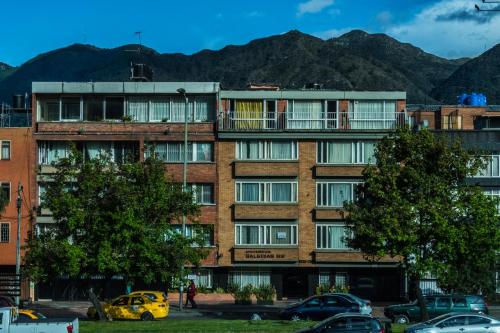 an apartment building with cars parked in a parking lot at Apartamentos Galerías in Bogotá