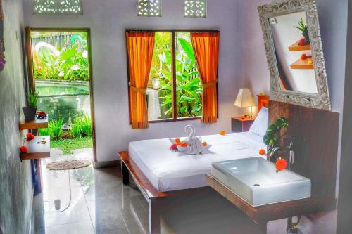 sypialnia z łóżkiem, umywalką i lustrem w obiekcie Canang Gardens w mieście Ubud