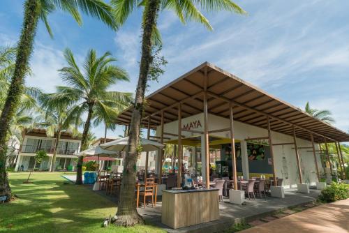 a restaurant with palm trees in front of it at The Briza Beach Resort, Khao Lak SHA Extra Plus in Khao Lak