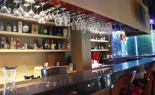 a bar with wine glasses hanging above a counter at Java Palace Hotel in Cikarang