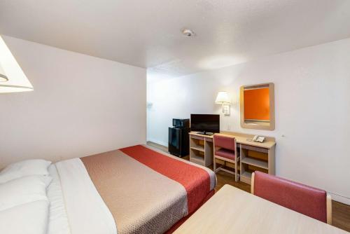 Habitación pequeña con cama y escritorio en Motel 6-Greenville, TX en Greenville