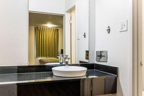 a bathroom with a sink and a large mirror at Motel 6-Alexandria, LA - South in Alexandria