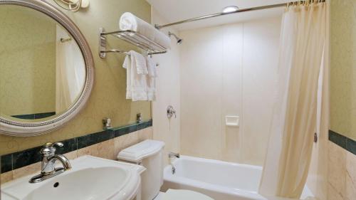 a bathroom with a sink and a toilet and a mirror at Best Western Queens Court in Queens