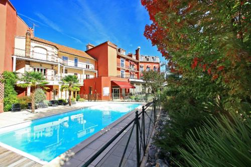 a swimming pool in front of a building at Best Western Beauséjour in Lourdes