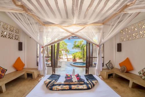 a bedroom with a bed and a large window at Zoi Boutique Hotel Zanzibar ex Sunshine Hotel in Matemwe