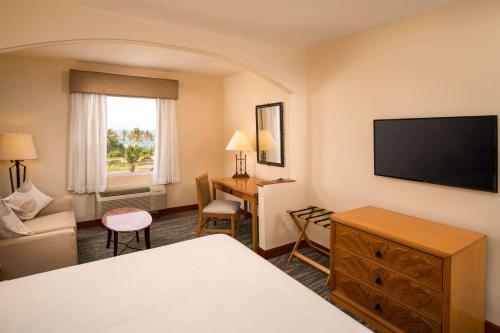 um quarto de hotel com uma cama e uma televisão em Quality Hotel Real Aeropuerto Santo Domingo em Boca Chica
