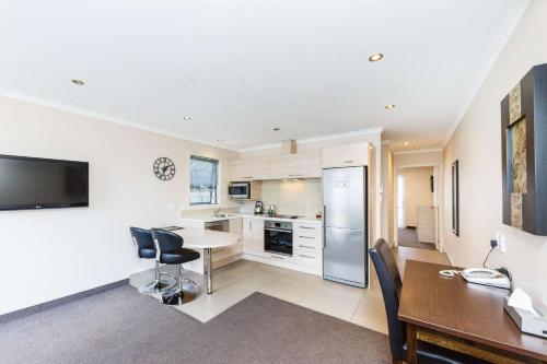 a kitchen and dining room with a table and chairs at Kauri Court Motel and Apartments in Palmerston North