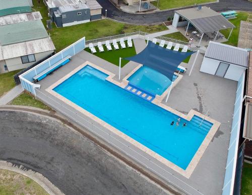 an overhead view of a swimming pool next to a house at Lakeside Cabins & Holiday Village in Sussex inlet