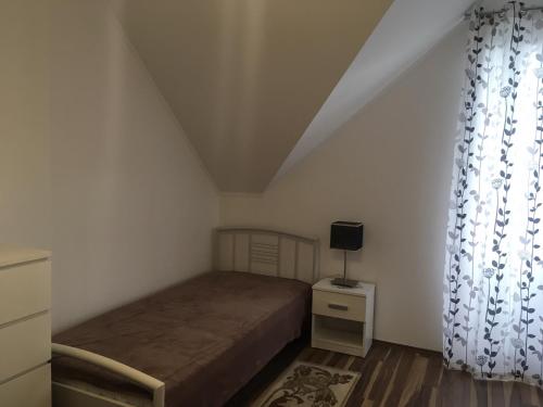 ein kleines Schlafzimmer mit einem Bett und einem Fenster in der Unterkunft Villapark Z/3 appartman in Zalacsány