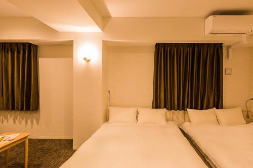 a hotel room with two beds and a table at EIWA PLACE HOTEL HAKATA - Former Hotel Ninestates Hakata in Fukuoka