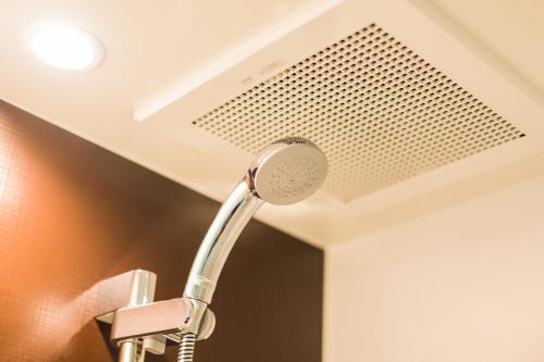 a shower head in a bathroom next to a ceiling at EIWA PLACE HOTEL HAKATA - Former Hotel Ninestates Hakata in Fukuoka