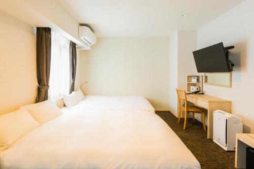 a hotel room with two beds and a desk at EIWA PLACE HOTEL HAKATA - Former Hotel Ninestates Hakata in Fukuoka
