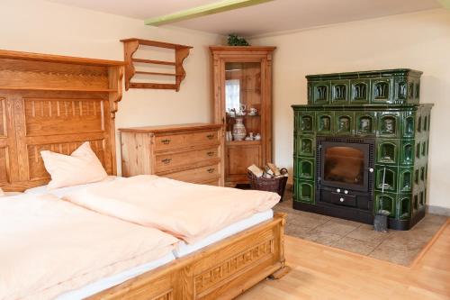 a bedroom with a bed and a green fireplace at Roubenka Anna in Dolní Polubný