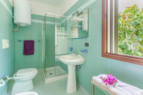 a bathroom with a toilet and a sink and a shower at Appartamento con prato inglese destro Salento in Specchiolla 